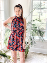 Load image into Gallery viewer, In front of palm plants, red and blue floral halter mini dress
