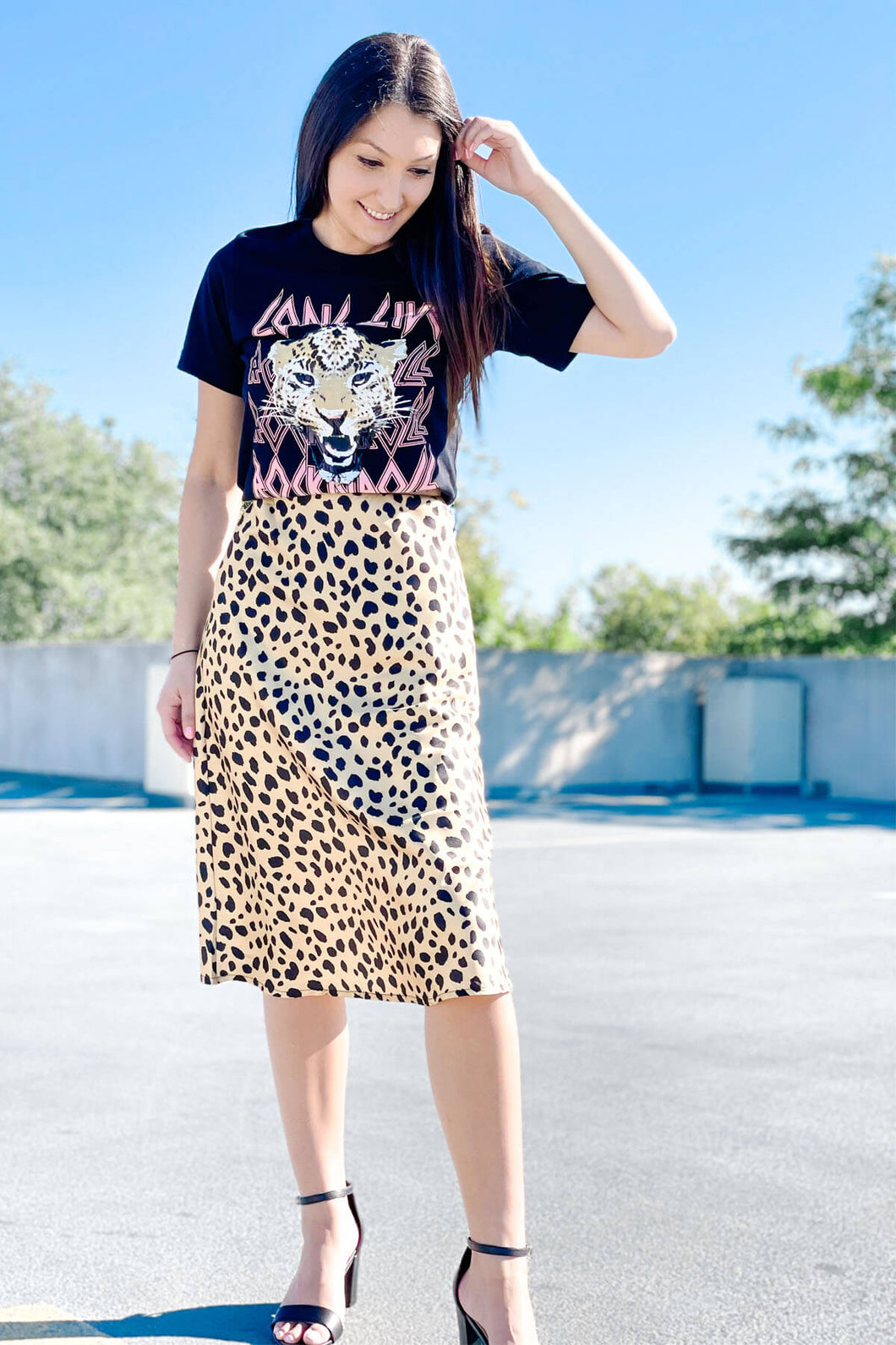 women's black long live rock and roll graphic tees paired with satin waist band gold leopard midi skirt and black strap heels