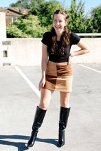 Load image into Gallery viewer, Brown mini suede skirt featuring a color block pattern and back zip closure. Paired with a black tshirt bodysuit and alligator knee high boots
