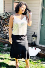 Load image into Gallery viewer, women&#39;s black mid length midi skirt with slit paired with gold glitter sequin sparkle tank top
