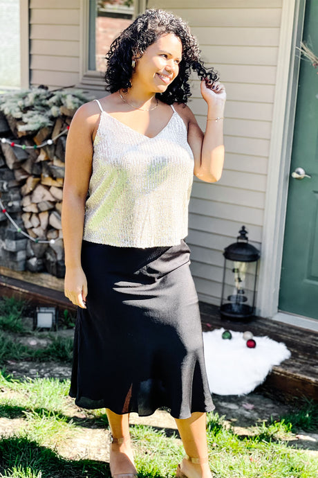 women's black mid length midi skirt with slit paired with gold glitter sequin sparkle tank top