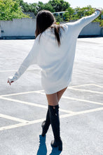 Load image into Gallery viewer, Back of women&#39;s white oversized long sleeve turtleneck sweater dress. Paired with knee high suede boots. 
