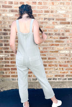 Load image into Gallery viewer, Back of blue distressed relaxed women&#39;s denim overalls. Paired with white ribbed cropped tank top and universal threads white sneakers. 
