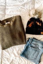 Load image into Gallery viewer, olive waffle knit long sleeve sweater, distressed skinny jeans and tie-dye pom winter hat flatlay
